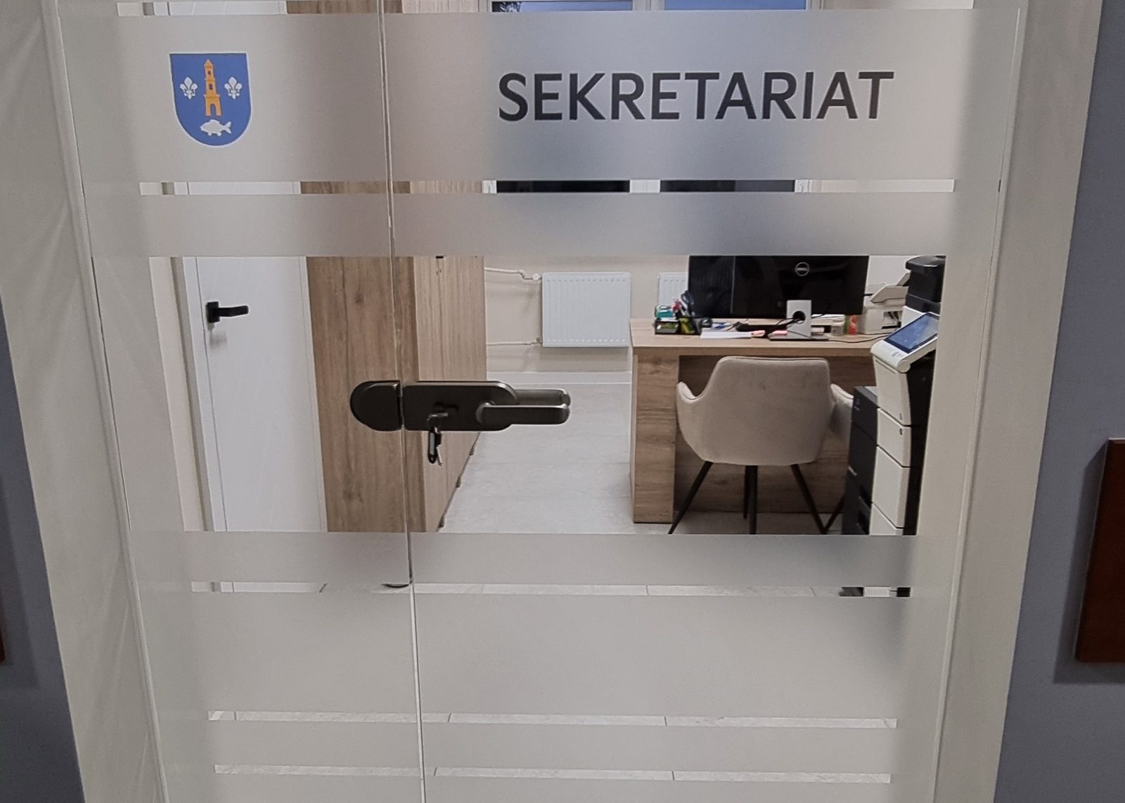 Szklana ścianka z wycinanym napisem i pasem folii mrożonej