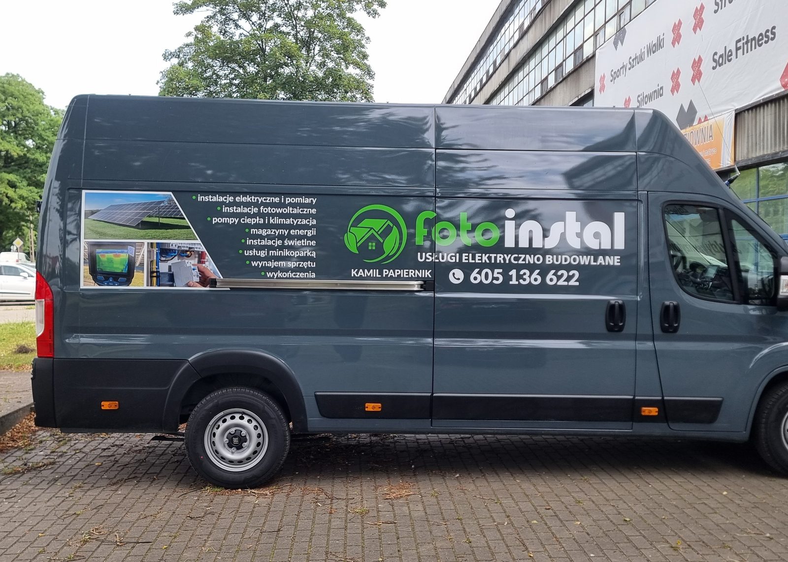 Bus firmy instalacyjnej z grafiką reklamową na boku