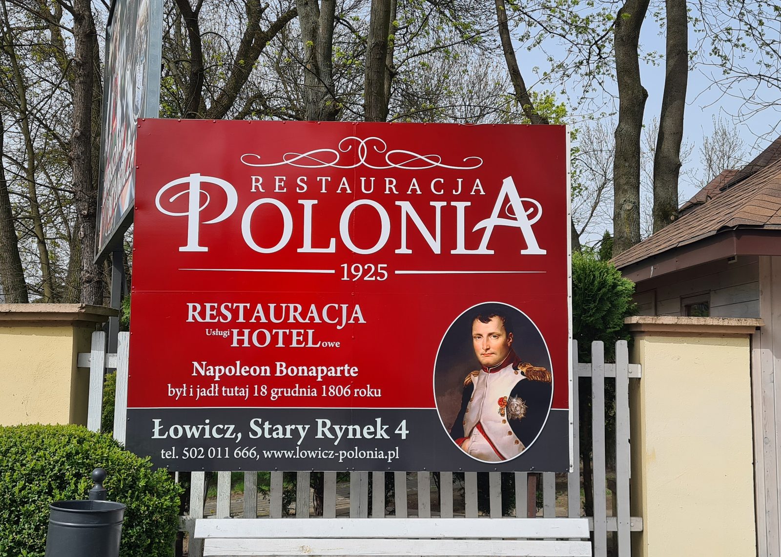 Szyld restauracji z nadrukiem zamontowany na elewacji